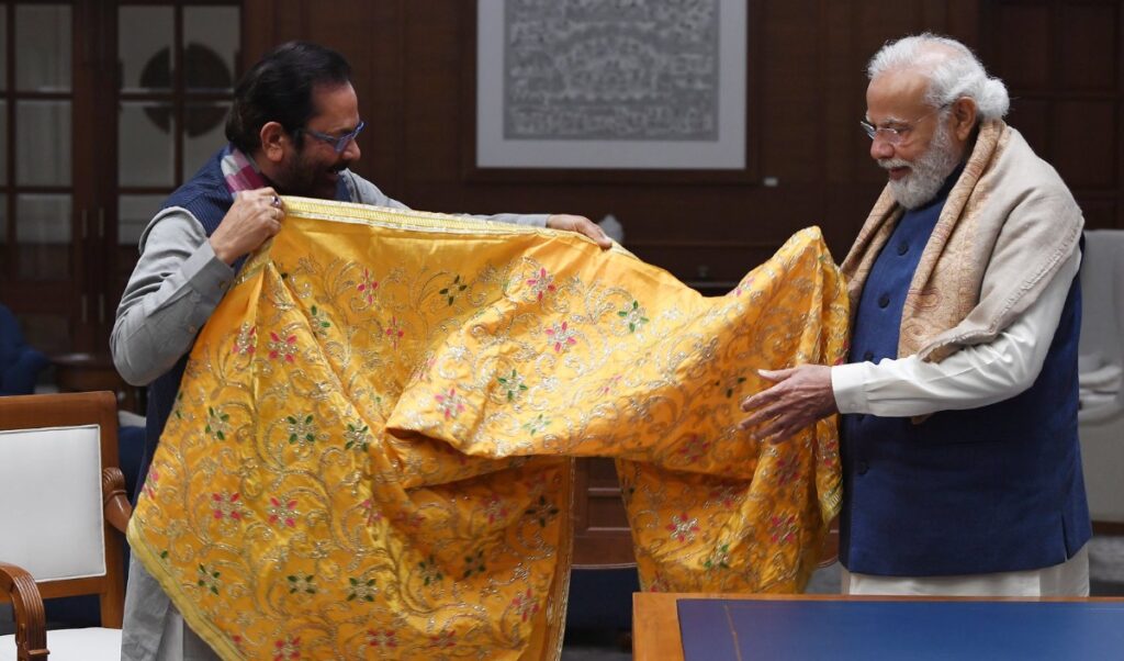 Prime Minister Narendra Modi on Wednesday presented a chadar to Minority Affairs Minister Mukhtar Abbas Naqvi, who was visiting